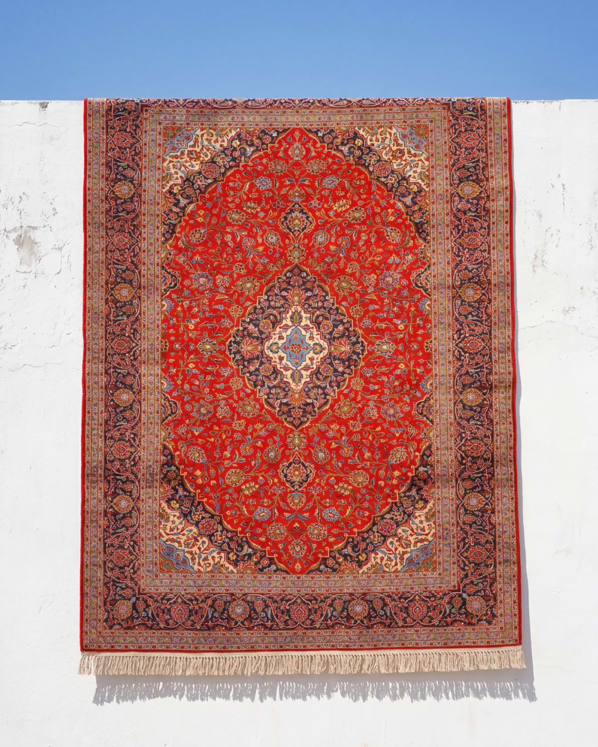 Handmade carpet hung for climate-controlled flat drying after washing