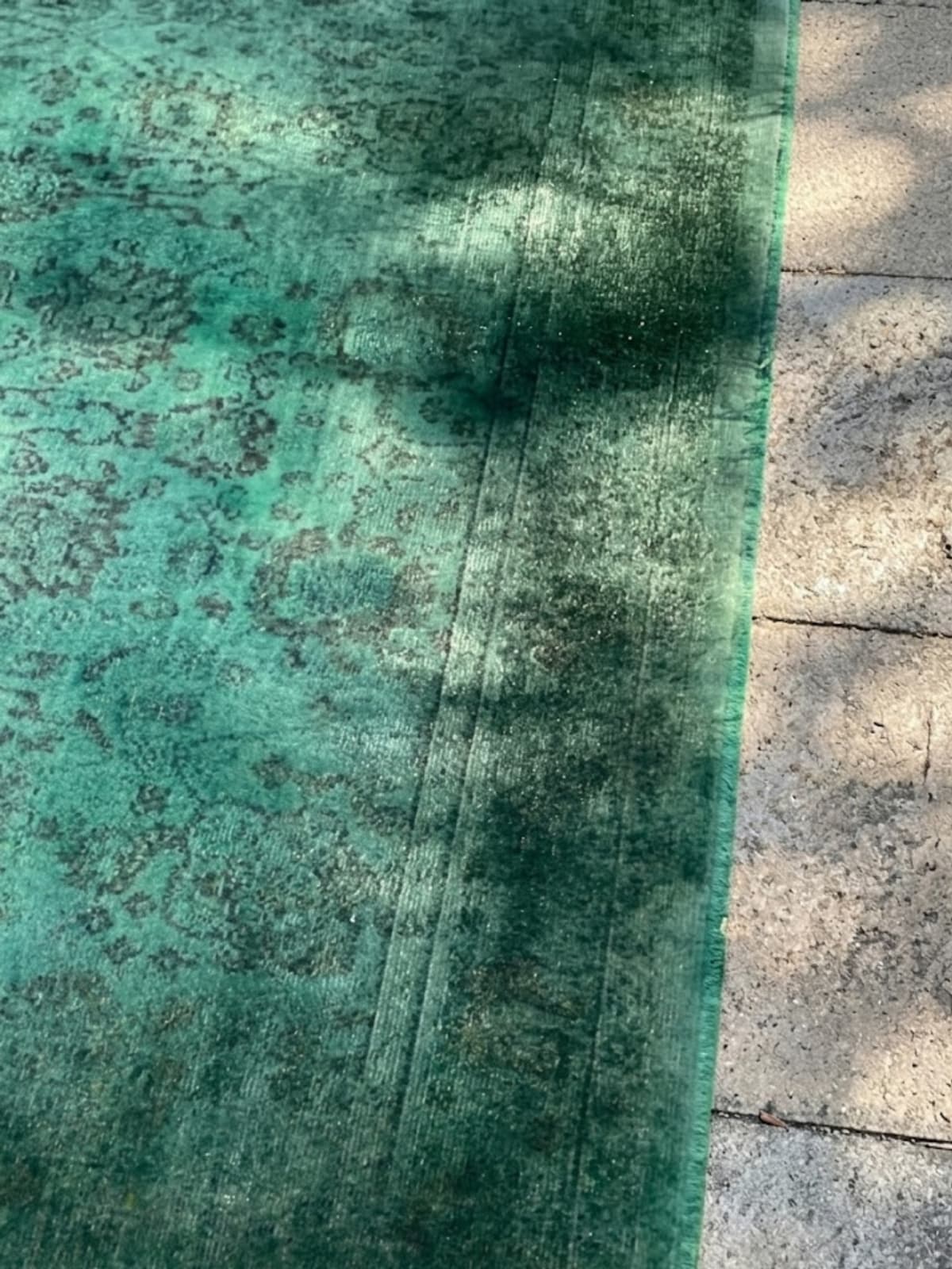 Sun-faded carpet section before archival colour restoration treatment