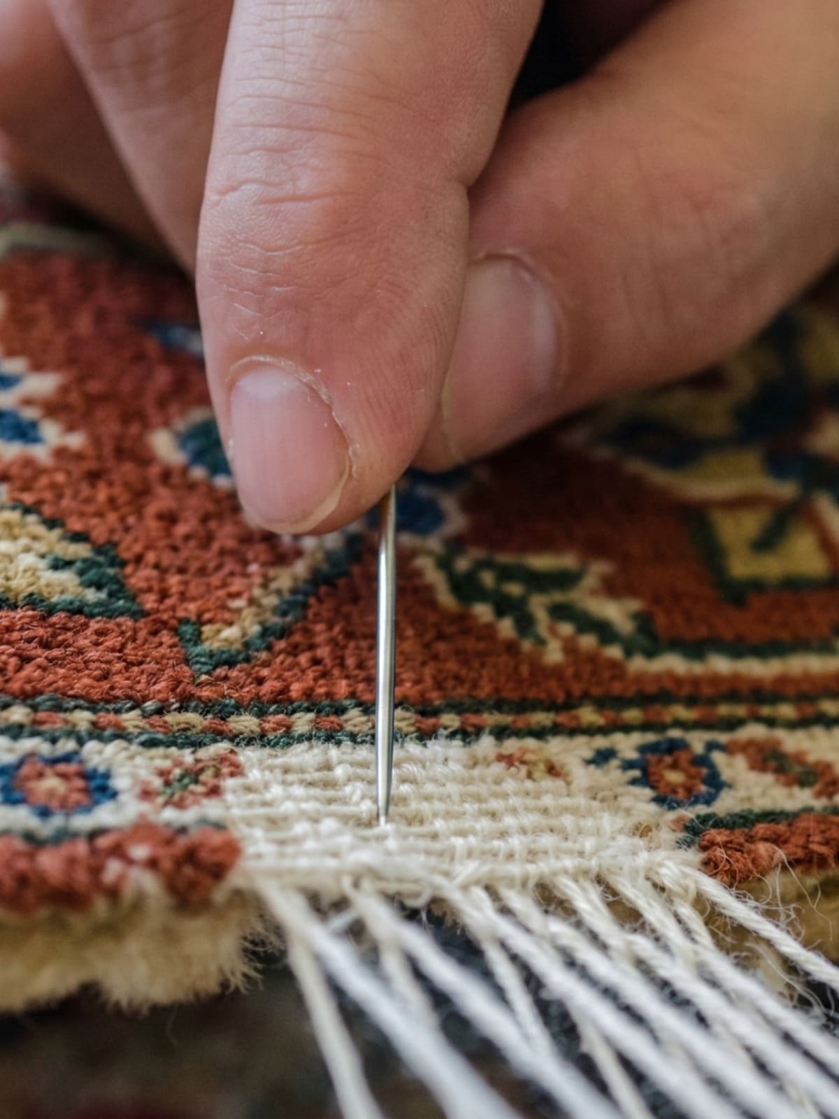 Carpet foundation warp and weft threads being reinforced during structural repair